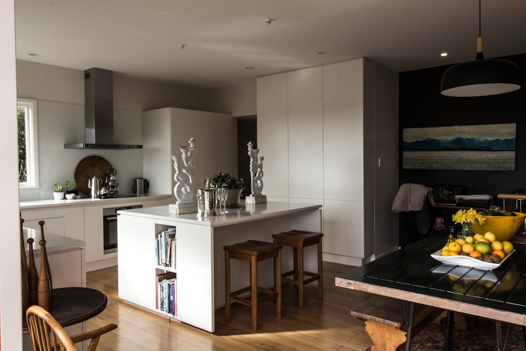 Modern kitchen and dining area with island and fruit bowl.